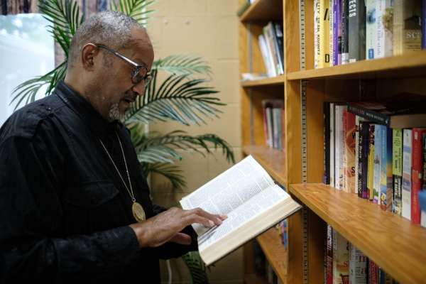 Photo of A man reading a book in a library.